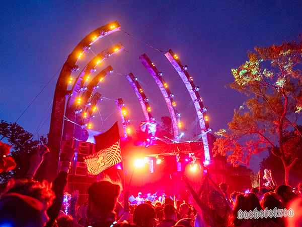 Festival stage lit up at night under the stars